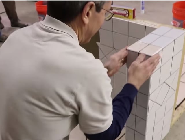 Scott checks the bullnose with his hands as it addresses the cut tile coming up the wall