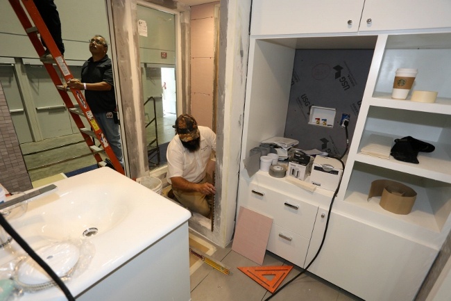 Experts from Visalia Ceramic Tile installing tile in the Retro Bungalow Tiny Home Bathroom
