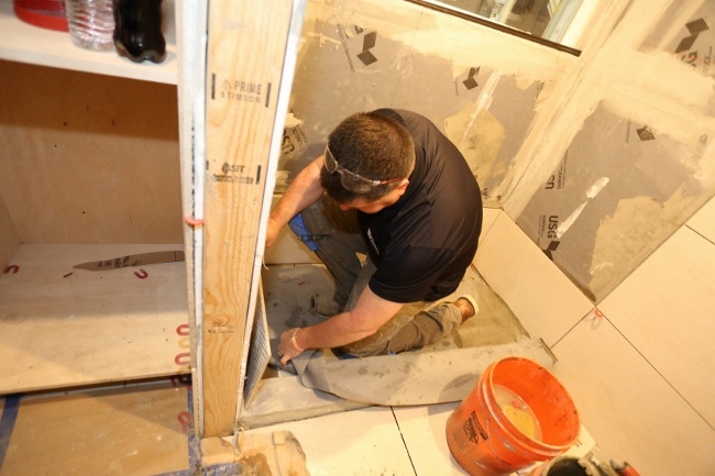 Welch Tile and Marble working on the shower in a tiled tiny house