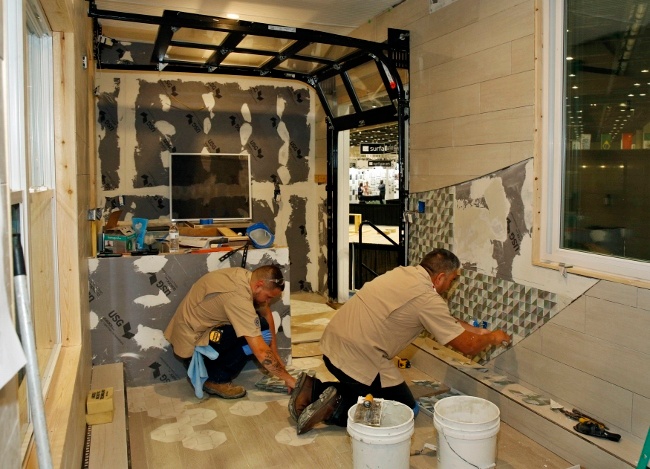 Installing tile on the walls and the floors of the tiny house