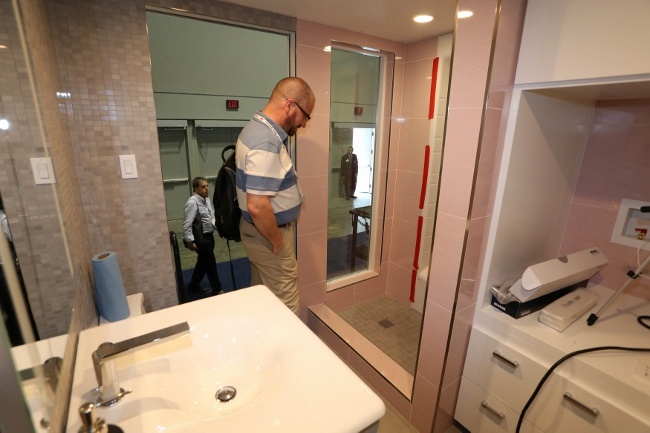 Coverings17 visitor admiring the tile work in the Retro Bingalow Tiny House bathroom