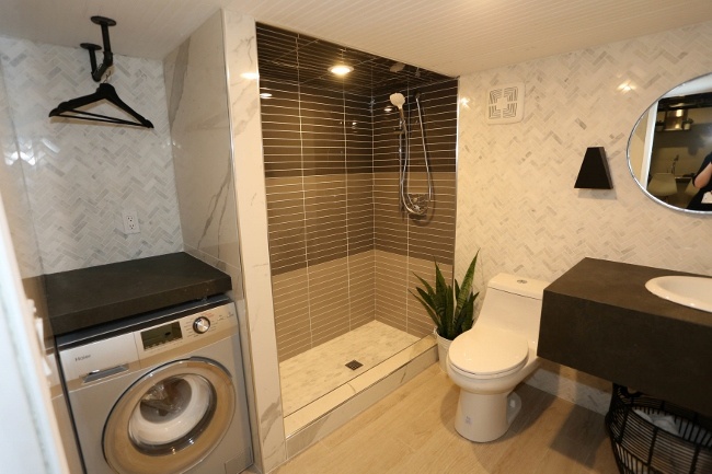 The bathroom in the tiled Vitruvian Tiny House is surprisingly large and very relaxing-looking.