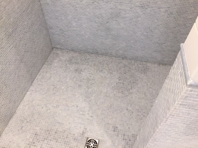A beautiful stone product exhibited discoloration after it had been installed in a shower floor and in use for about one year.